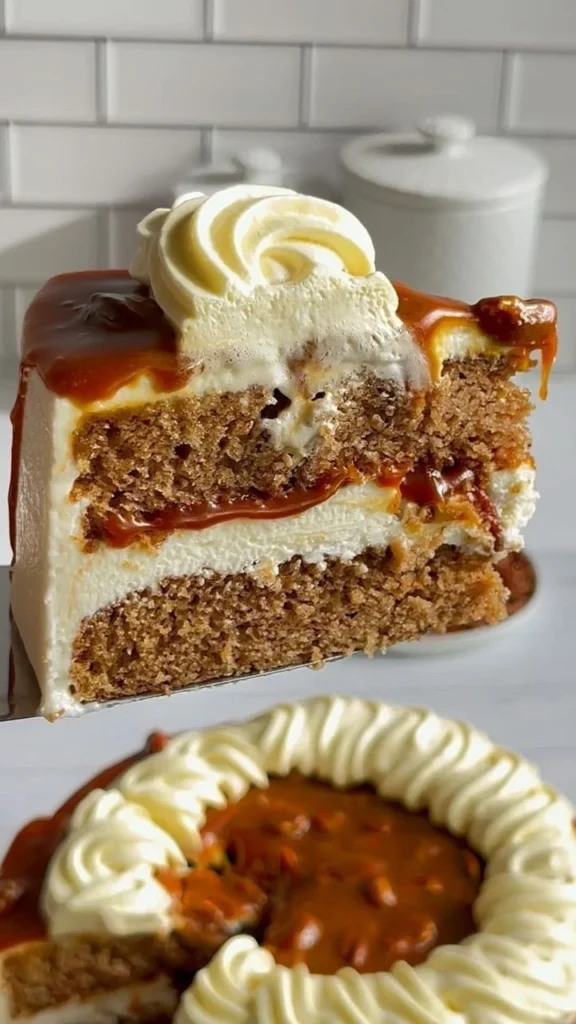 Caramel spice cake with cream cheese frosting and toasted pecans on a serving plate
