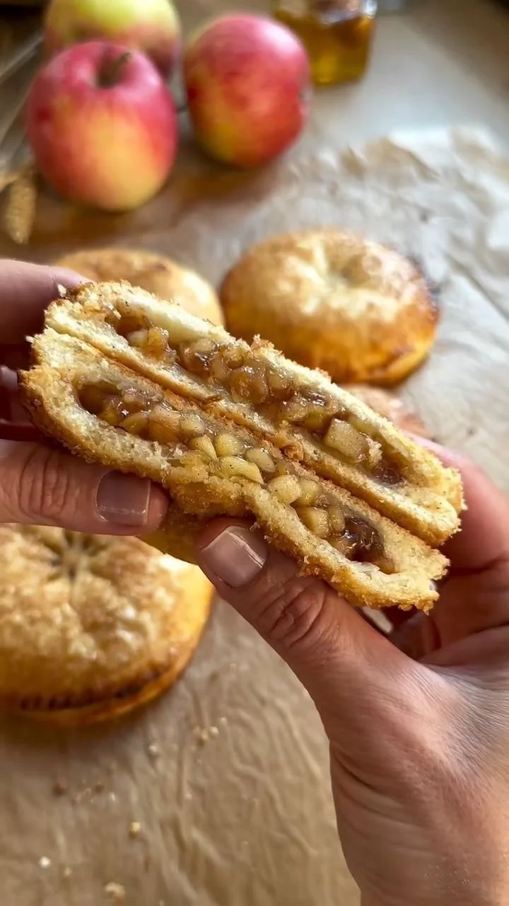 Freshly baked apple cinnamon buns with a golden crust and cinnamon swirl