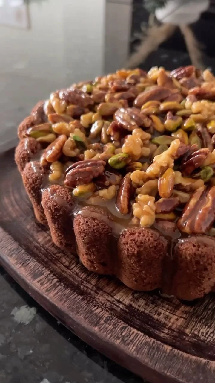 A delicious slice of Walnut Caramel Cake topped with walnuts and drizzled with caramel.