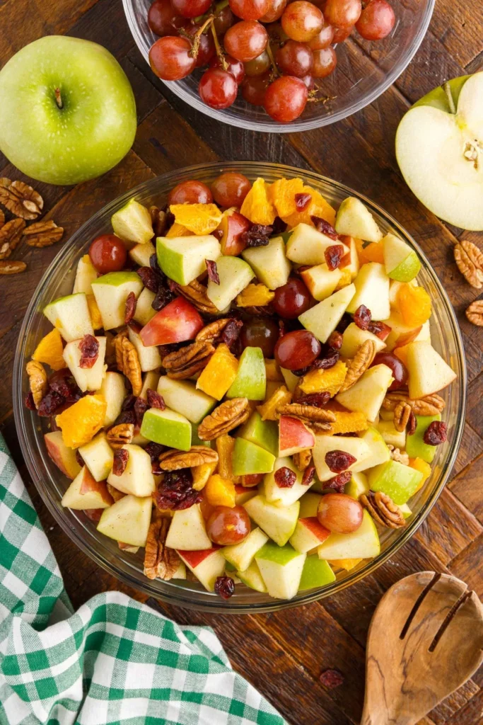 A colorful Thanksgiving fruit salad with assorted fresh fruits and herbs.