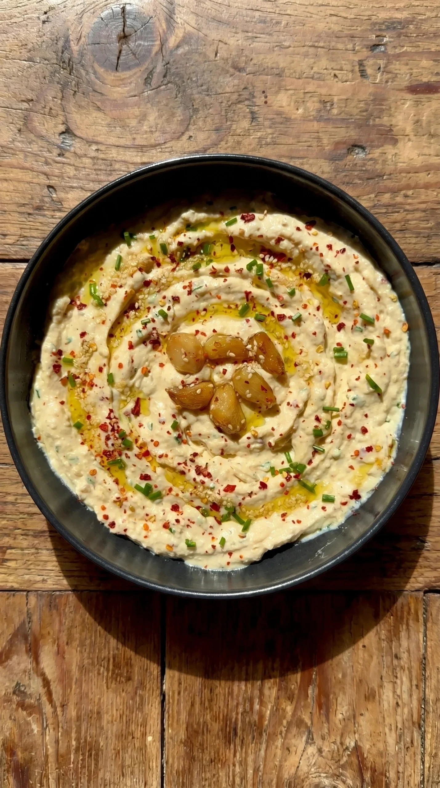 Creamy roasted garlic dip served with fresh vegetables and bread