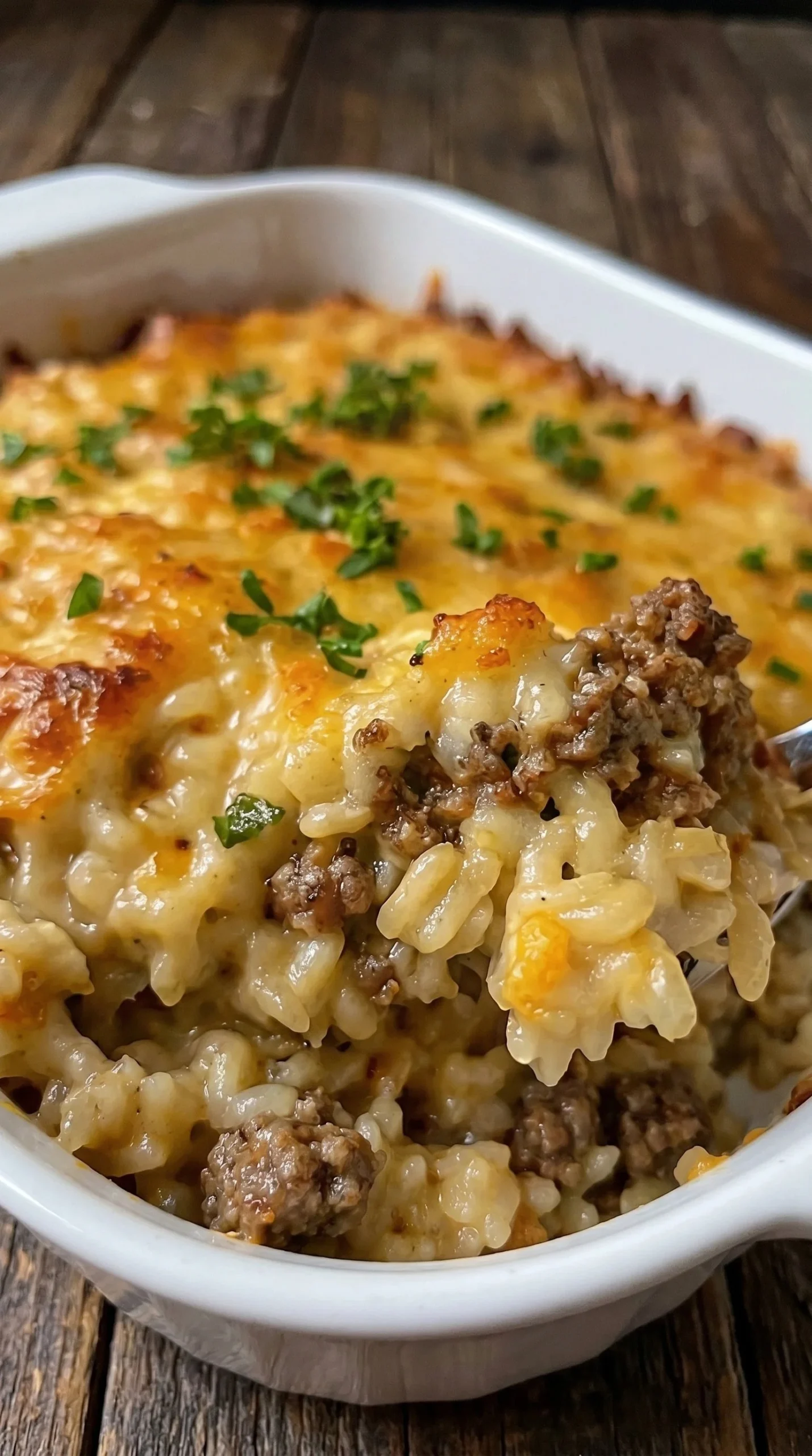 Cheesy Ground Beef Rice Casserole topped with melted cheese and fresh herbs